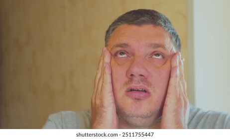 Headache. Stress and emotional load of modern man. Middle-aged man struggling with stress. Close-up portrait.