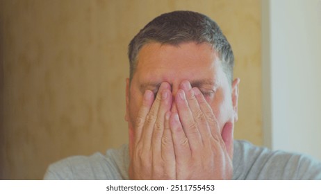 Headache. Stress and emotional load of modern man. Middle-aged man struggling with stress. Close-up portrait.