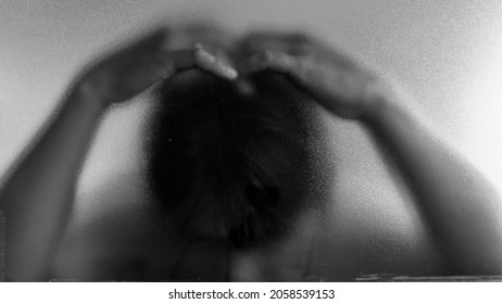 Headache Symbol. Shadow Hands Of The Man Behind Frosted Blurred Glass. Blurry Hand Abstraction. Black And White Halloween