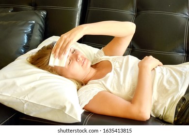 Headache. Woman Lying On Sofa With Tissue On His Forehead. Suffering From Headaches. Chronic Migraine. Early Menopause. A Tired Woman. Coronavirus