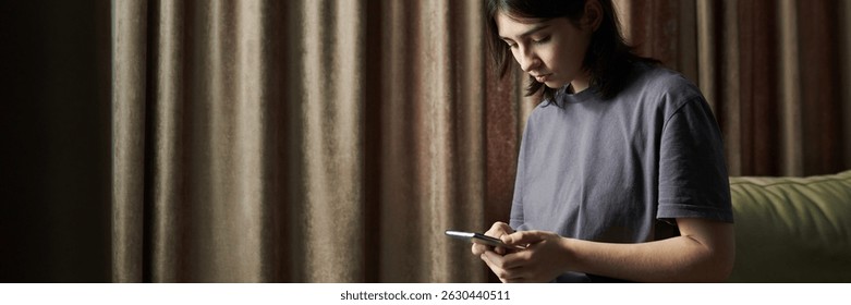 Заголовок лица, держащего смартфон, стоя возле окна со шторами. Использование смартфона и взгляд на экран с фокусированным выражением