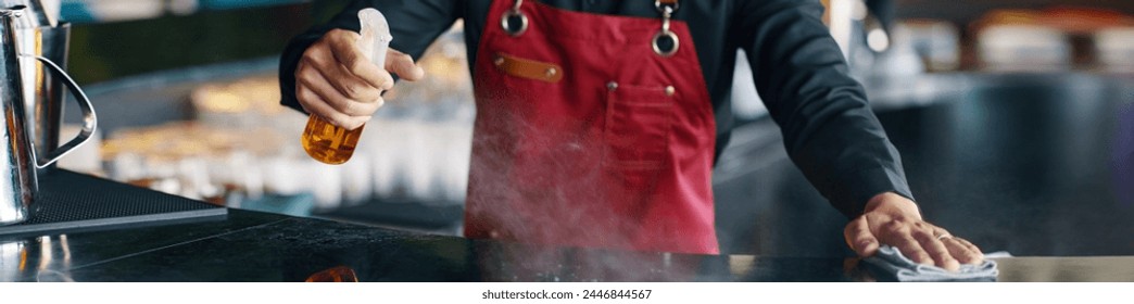 Header with restaurant waiter cleaning bar counter before opening - Powered by Shutterstock