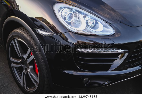 headlight of a black car side view close-up.\
details of a modern premium business\
car