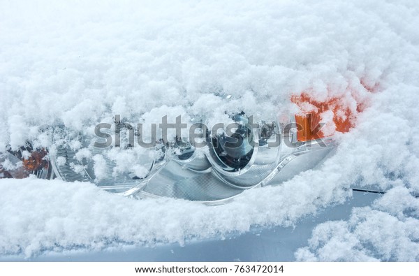 The headlight\
of the car is covered with\
snow