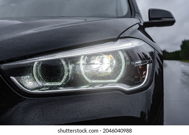 Headlight Lamp Of New Car On Road In Rainy Day.