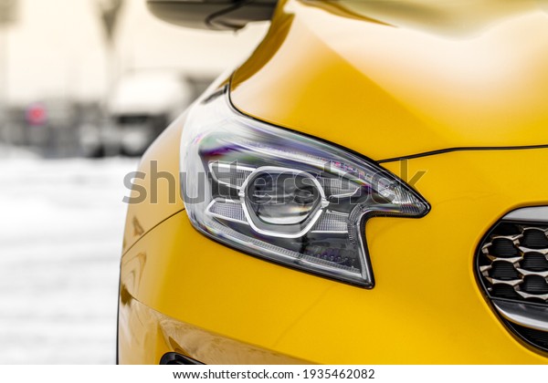Headlight lamp of new cars. Close up detail on one\
of the LED headlights modern yellow car. Exterior closeup detail.\
Closeup headlights of\
car.