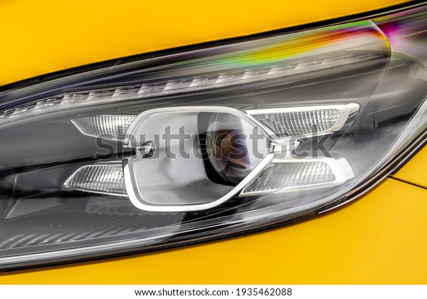 Headlight lamp of new cars. Close up detail on one\
of the LED headlights modern yellow car. Exterior closeup detail.\
Closeup headlights of\
car.