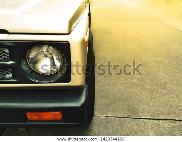 Headlight lamp of vintage classic golden car\
with sunlight\
background.