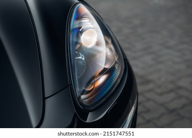 The headlight of the modern luxury car close up. The front side of a clean black SUV car. 
