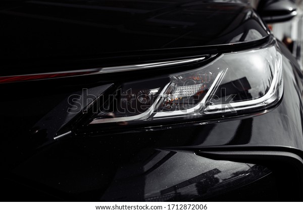 headlight of modern prestigious black car close up.\
Close up photo of modern car, detail of headlight. Headlight car\
Projector LED of a modern luxury technology and auto detail.\
selective focus