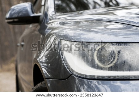 headlight of modern prestigious car closeup. drops of fog or rain, condensation. beautiful headlights of a car. part of the front, the car is unrecognizable. glowing headlight, for lighting