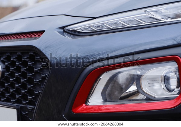 headlight of modern prestigious car closeup.\
beautiful headlights of a car. dark gray color, red edging. part of\
the front, the car is unrecognizable. direction indicators on a\
sports car. macro\
photo