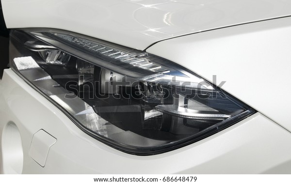 Headlight of a modern sport car. The\
front lights of the car. Modern Car exterior\
details