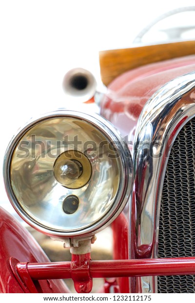 The headlight of the old\
car. Veteran car with large chrome light,close up. Front mask of\
retro car.