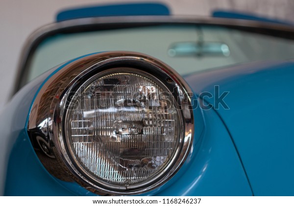 The\
headlight of an old, rarity, vintage blue\
car.