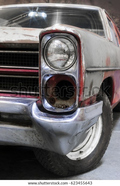 Headlight of old retro car\
with rust on bodywork, recovery of vintage automobile, selective\
focus 