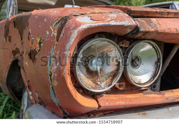 Headlight of an old rusty abandoned car,\
utilisation and scrap\
concept.