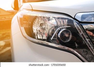 Headlight And Radiator Grille Of A Beautiful Matte White Car With Yellow Tint