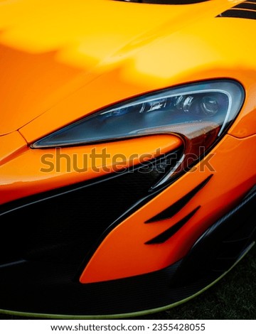 Headlight of a super sport orange car.