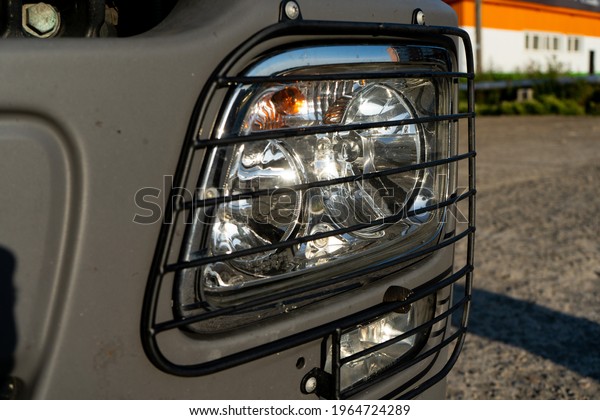 Headlight of a truck\
with a protective\
grill.