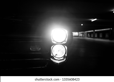 headlights of an american classic muscle car shining in camera - Powered by Shutterstock