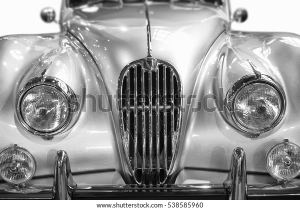 headlights of an antique\
silver jaguar car