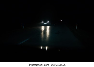 The Headlights Of A Car Coming To Meet At Night.