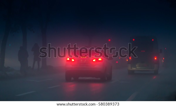 Headlights of cars\
driving in fog at\
night