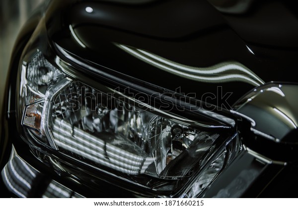Headlights and hood of\
black car with shine