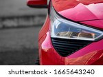 Headlights and hood of sport red car with silver stars. Car detail