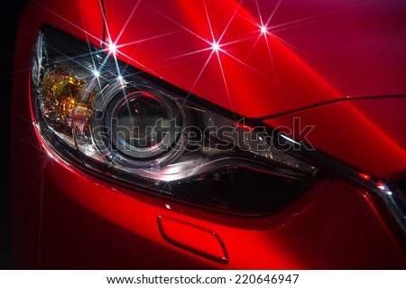 Headlights and hood of sport red car with silver stars