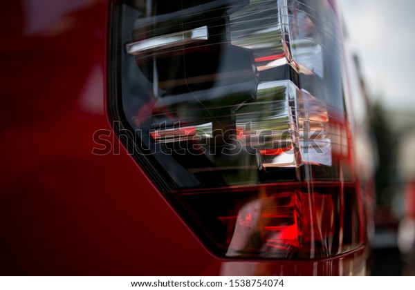 Headlights of a red car.\
headlights of a new red car. Headlight on modern car. Headlight\
with led lamps and hood of red sport modern car. Exterior detail.\
luxury concept