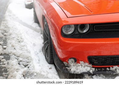 Headlights and soot of a red sports car on the snow. Beautiful Muscle car in the snow.