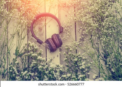 Headphone With Frame Of Beautiful Flower On Wooden Background Music Therapy Concept