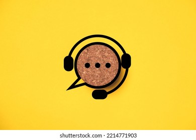 Headphone logo with speech bubble message icon on round wooden for support and customer service concept.