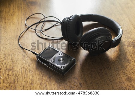 Headphone with music player on wooden table