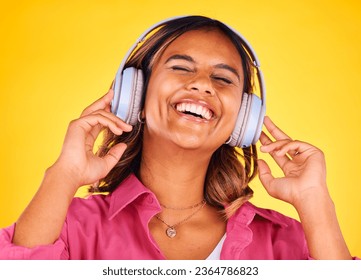 Headphones, excited and young woman in a studio listening to music, playlist or radio for entertainment. Happy, technology and female model from Mexico streaming a song or album by yellow background. - Shutterstock ID 2364786823