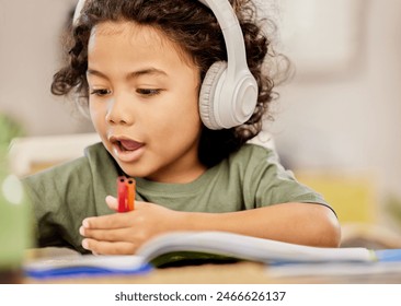 Headphones, kid and homework with book on table for learning, knowledge or listening to music. Kindergarten, education and boy with tech at home for child development, homeschool and audio in project - Powered by Shutterstock