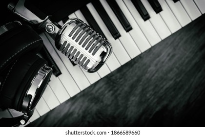 Headphones and microphone on the piano keyboard. Recording studio concept.
