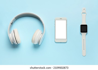 Headphones, mobile phone and smart watch on color background - Shutterstock ID 2109002873