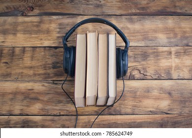 Headphones on the Pile of Books on the Wooden Table. Audiobooks. Learning through Audiobook.