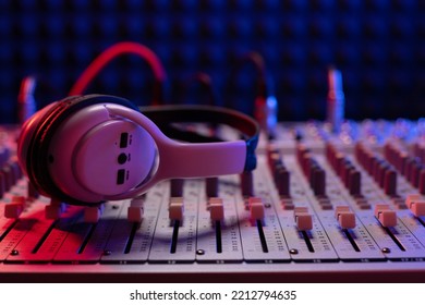 Headphones at sound mixer with faders and auido cable jack. Music concept in sound recording studio