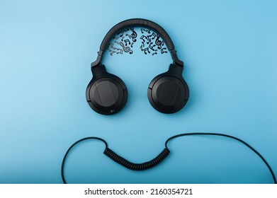 Headphones And Wire Imitating The Face Of A Funny Dude With Musical Notes Instead Of The Brain On The Blue Background