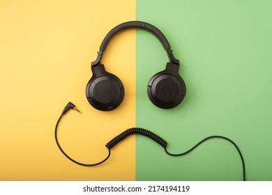 Headphones And Wire Imitating The Face Of A Funny Dude On The Yellow And Green Background