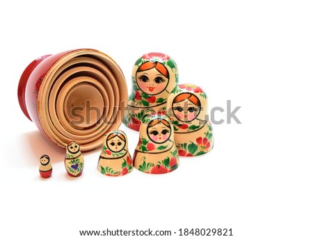 Heads from nesting dolls are lined up in a semicircle around the assembled lower part, lying on its side