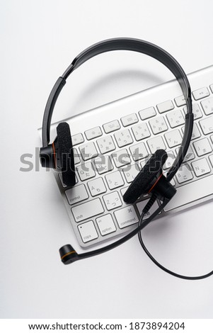 Headset and computer keyboard on white background