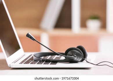 Headset and laptop on table of technical support agent in office