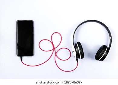 Headset and a phone on a white background. Ready to listen to music.