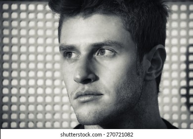 Headshot Of Attractive Young Man Looking To A Side, Against Grid Background, Black And White Shot