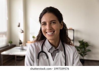 Headshot Close Up Portrait Of Smiling Young Caucasian Female Doctor In Medical White Uniform In Clinic. Profile Picture Of Happy Confident Successful Woman Nurse GP In Hospital. Healthcare Concept.